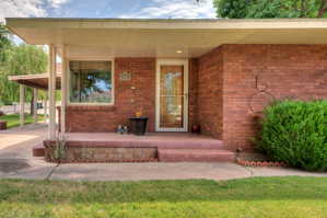 View of front entry with brick siding and covered porch