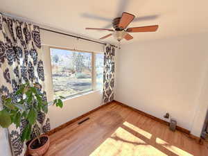 Unfurnished room featuring wood-type flooring and ceiling fan