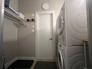 Laundry room with stacked washer / drying machine and open closet.