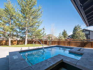 View of pool with a fenced backyard and patio surround