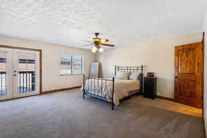 Primary bedroom featuring french doors, access to outside, a textured ceiling, and ceiling fan