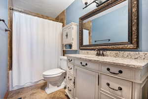 Full primary bathroom featuring vanity, a textured ceiling, and shower / bathtub combination with curtain