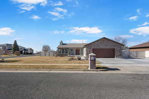 Single story home featuring driveway, an attached garage, a gate, a chimney, and a residential view