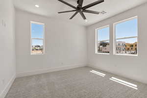 Empty room with light carpet, a ceiling fan, and recessed lighting