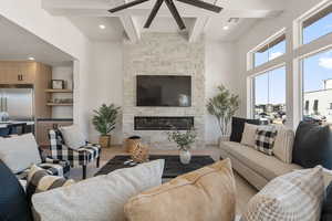 Living room featuring a fireplace, wood finished floors, a ceiling fan, and recessed lighting