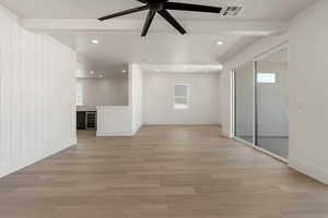 Spare room with recessed lighting, wine cooler, light wood-type flooring, a ceiling fan, and beam ceiling