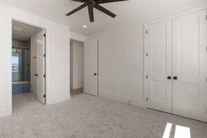 Unfurnished bedroom featuring light carpet, a closet, ensuite bath, and a ceiling fan