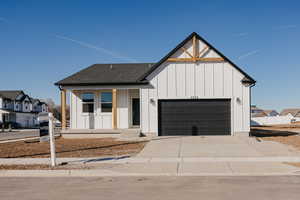 Modern farmhouse featuring board and batten siding, a porch, concrete driveway, a garage, and a shingled roof