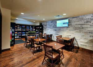 Dining room with hardwood / wood-style floors, recessed lighting, and wood walls