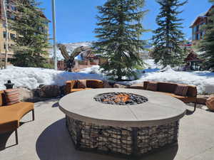Snow covered patio with a fire pit and a patio area