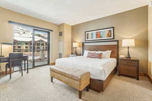 Carpeted bedroom with access to exterior and baseboards