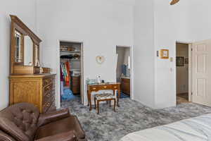 Bedroom featuring a high ceiling, a walk in closet, and carpet floors