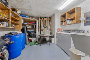 Laundry area featuring washer and dryer and a textured ceiling