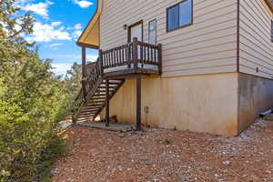 View of side of property featuring stairs and a deck