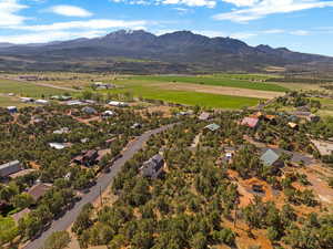 Aerial view of property and surrounding area with a mountain backdrop and nearby suburban area