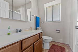 Bathroom featuring an enclosed shower, vanity, and light floors