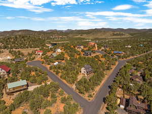 Aerial overview of property's location featuring a mountainous background and nearby suburban area
