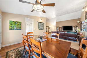 Dining area with wood finished floors, lofted ceiling, and ceiling fan
