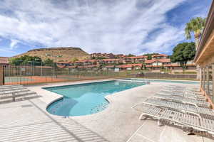 Community pool with a patio area and a residential view