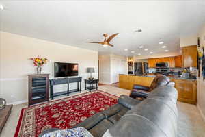 Living room with recessed lighting, light colored carpet, ceiling fan, and a textured ceiling