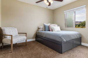 Carpeted bedroom featuring baseboards and a ceiling fan