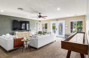 Living area with french doors, plenty of natural light, recessed lighting, a textured ceiling, and a ceiling fan