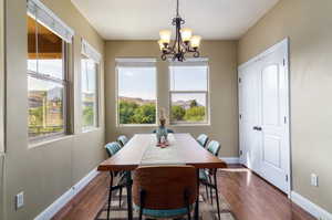 Dining room featuring dark wood-style flooring, a mountain view, and hanging lights