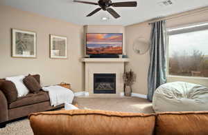 Living room with a ceiling fan, carpet, a fireplace, and recessed lighting