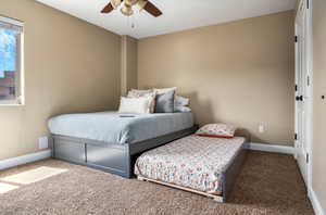 Carpeted bedroom with baseboards and a ceiling fan