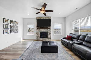 Living area featuring a ceiling fan, light wood-style flooring, a fireplace, and recessed lighting