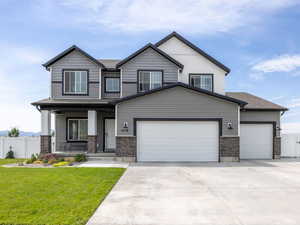 Craftsman inspired home with a gate, covered porch, driveway, and a garage