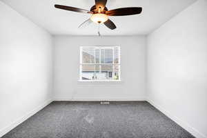 Empty room featuring carpet floors and a ceiling fan
