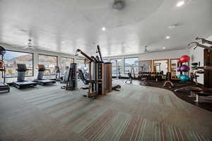 Gym featuring a textured ceiling, ceiling fan, and recessed lighting