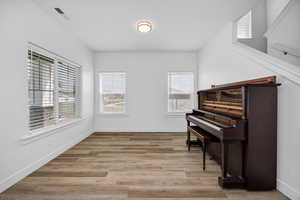 Sitting room with light wood-type flooring and baseboards