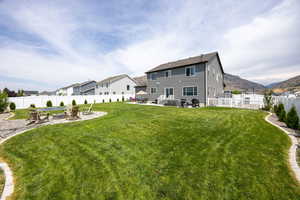 Back of house with a patio area, a fenced backyard, a fire pit, and a mountain view
