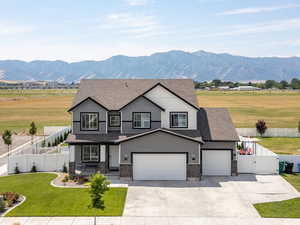 View of front of property with a gate, covered porch, driveway, a shingled roof, and a mountain view