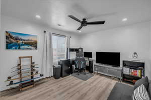 Office space with light wood-style flooring and ceiling fan