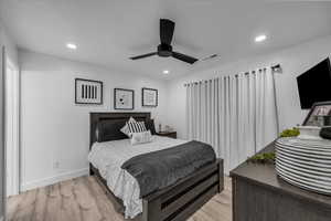 Bedroom with light wood finished floors, ceiling fan, and recessed lighting