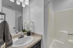 Bathroom featuring curtained shower and vanity