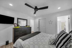 Bedroom featuring light wood-style flooring, ceiling fan, and recessed lighting