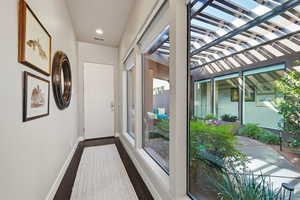 Doorway to outside with wood finished floors and recessed lighting