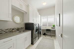 Laundry area featuring cabinet space, washing machine and dryer, an office area, and light tile patterned floors