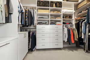 Walk in closet with light colored carpet