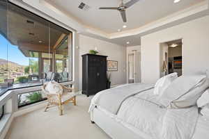 Carpeted bedroom featuring a tray ceiling, a mountain view, access to exterior, a ceiling fan, and recessed lighting