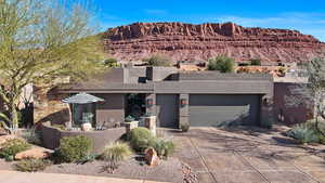 Southwest-style home with driveway, stucco siding, an attached garage, and a mountain view