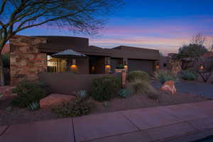 Pueblo-style home featuring stucco siding, concrete driveway, and an attached garage