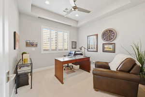 Office area with a raised ceiling, light colored carpet, a ceiling fan, and recessed lighting