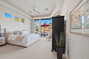 Bedroom featuring carpet flooring, a tray ceiling, recessed lighting, and ceiling fan
