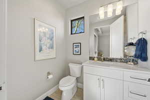 Half bathroom with vanity and light tile patterned flooring