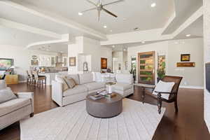 Living area featuring dark wood-type flooring, a ceiling fan, and recessed lighting